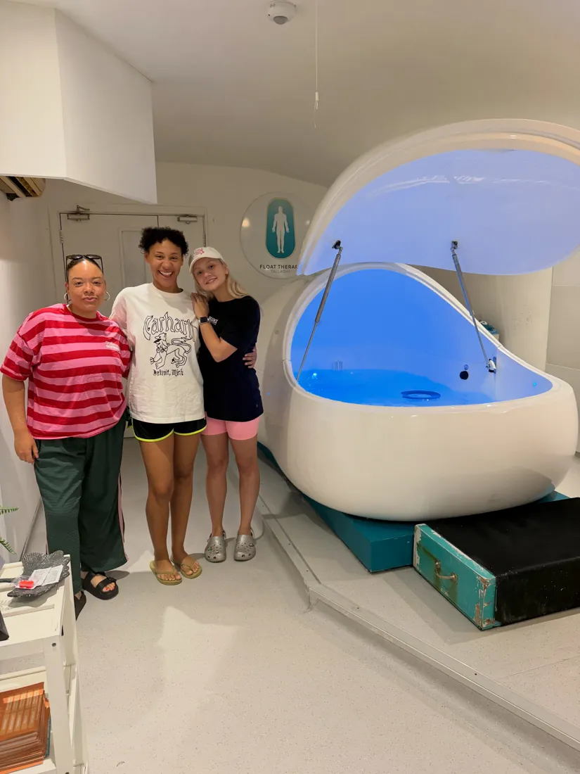 Three smiling customers beside a lit float pod