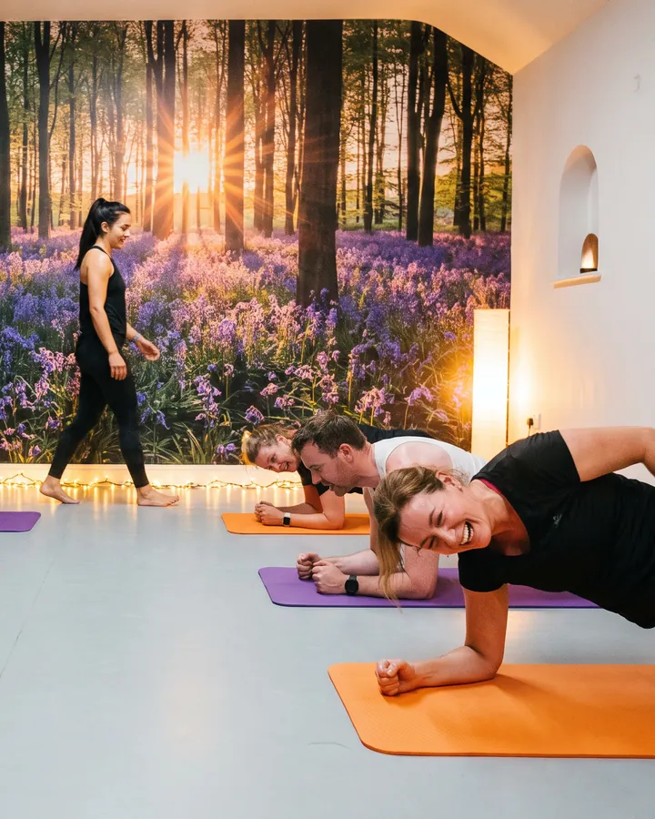 Students holding a plank on orange and purple mats